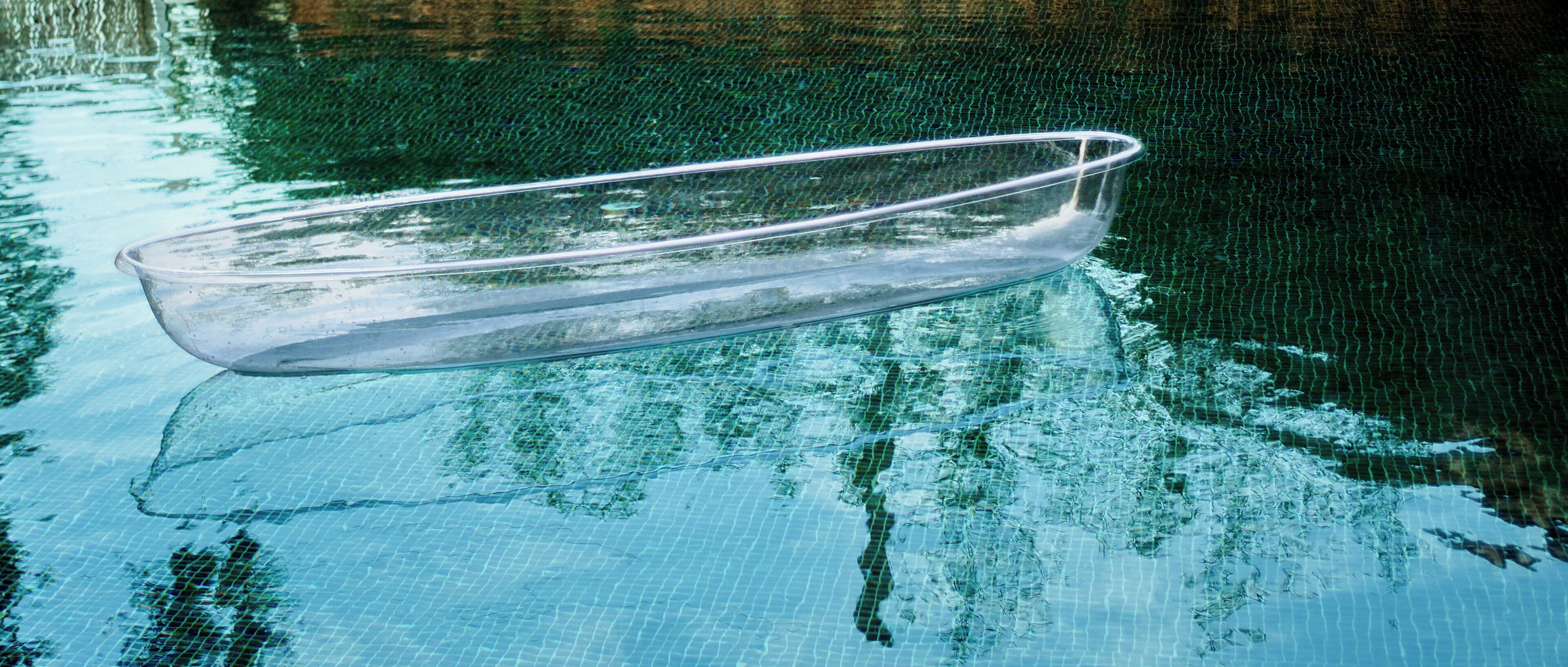 Un tazón de vidrio transparente flotando en el agua.