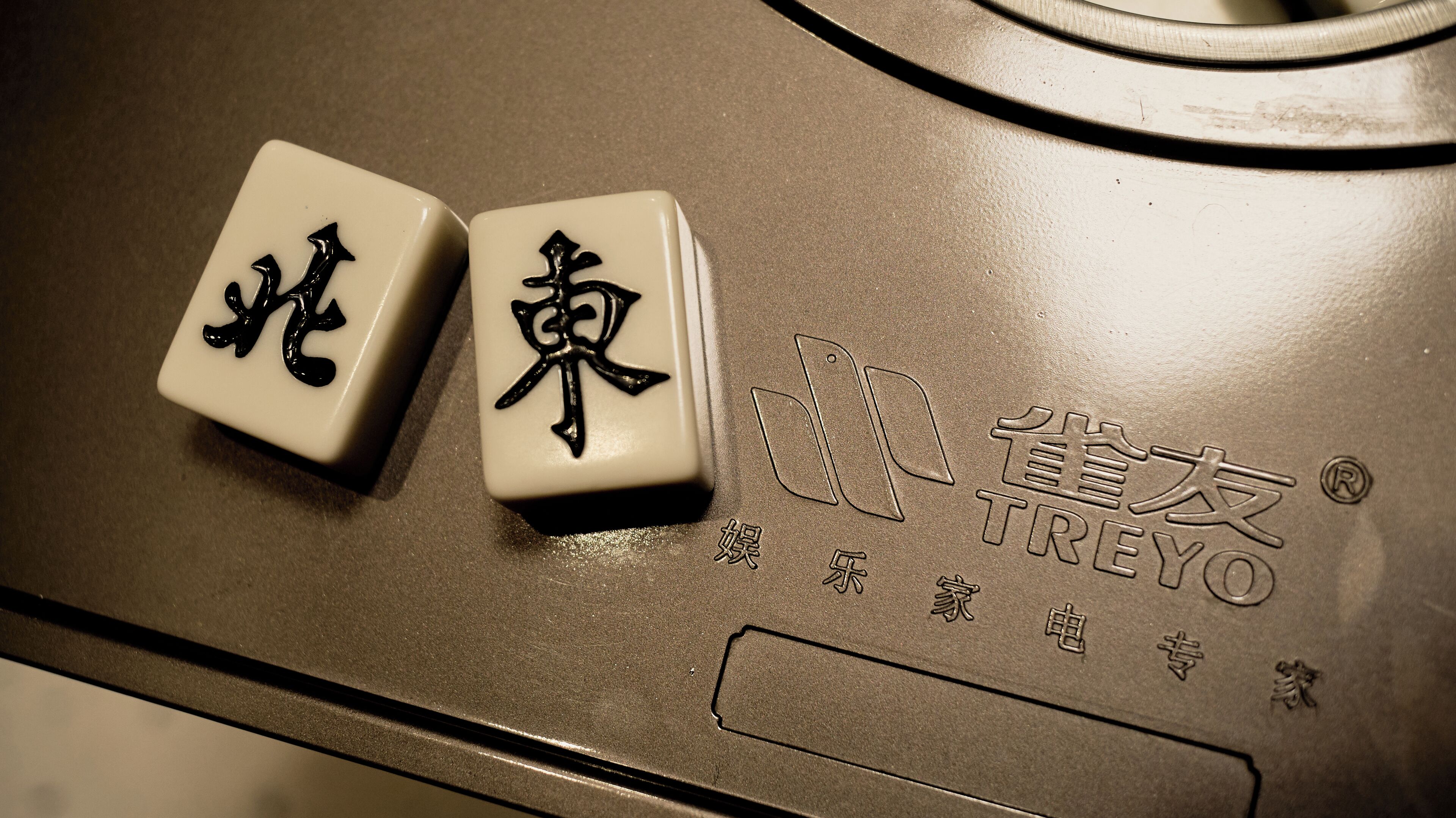 Two white tiles with black Chinese characters on a metallic surface, likely part of a restroom or public area.