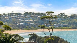 A coastal residential area with houses on a hillside, a beach, and a view of the ocean. - Aerial Blue Mollymook - Ocean Views, Spacious, Wood Fireplace, Walk to Mollymook Beach & Golf Course (Mollymook)