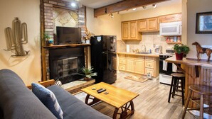 Un espacio habitable pequeño con chimenea, cocina y zona de estar.