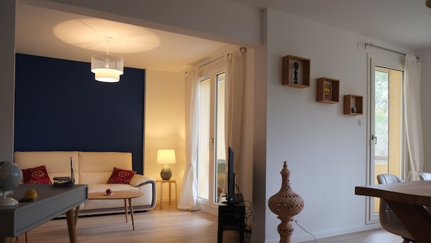 A living room with a sofa, a coffee table, a lamp, a television, and a decorative vase.