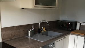 A modern kitchen with a built-in dishwasher, a double sink, and a Bosch induction cooktop.