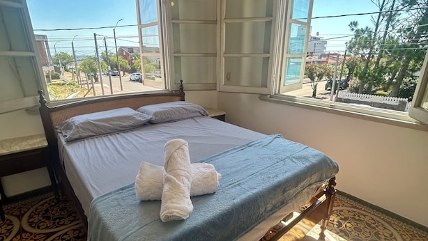 A bedroom with a bed, a window, and patterned floor tiles. - 100 meters from the sea in Piriapolis Downtown Piriapolis Full house w/ barbecue and garage (Piriápolis)