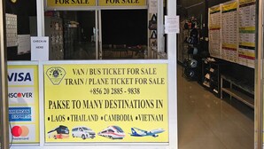 Ein Reisebüro mit Schildern, die Bustickets und Tourenangebote verkaufen, sowie Kontaktinformationen für Reiseleistungen zu verschiedenen Zielen.