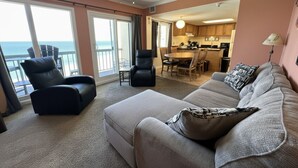 A living room with a sofa, armchair, and a view of the ocean through large windows. - Ocean and Lake Views w/ 3 Pools Gym Tennis (Panama City Beach)