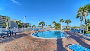 A pool area with blue lounge chairs, a brick patio, and palm trees. - Ocean and Lake Views w/ 3 Pools Gym Tennis (Panama City Beach)