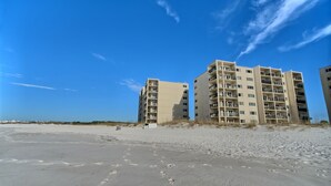 A beachfront hotel with multiple floors, balconies, and a sandy beach in the foreground. - Ocean and Lake Views w/ 3 Pools Gym Tennis (Panama City Beach)