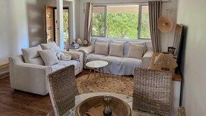 A modern living room with a sofa set, a coffee table, and wicker chairs. - Sunny Byron Bay House Just 700m from the Beach (Lennox Head)