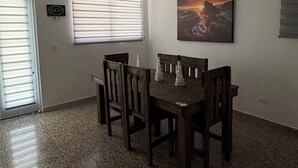 Ein Essbereich mit Holztisch und -stühlen, einem Bild an der Wand und einem Schild mit der Aufschrift 'KEYS' an der Tür.