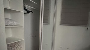 Ein Zimmer mit einem großen Spiegel, einem Schrank mit Regalen und einem Teppichboden.
