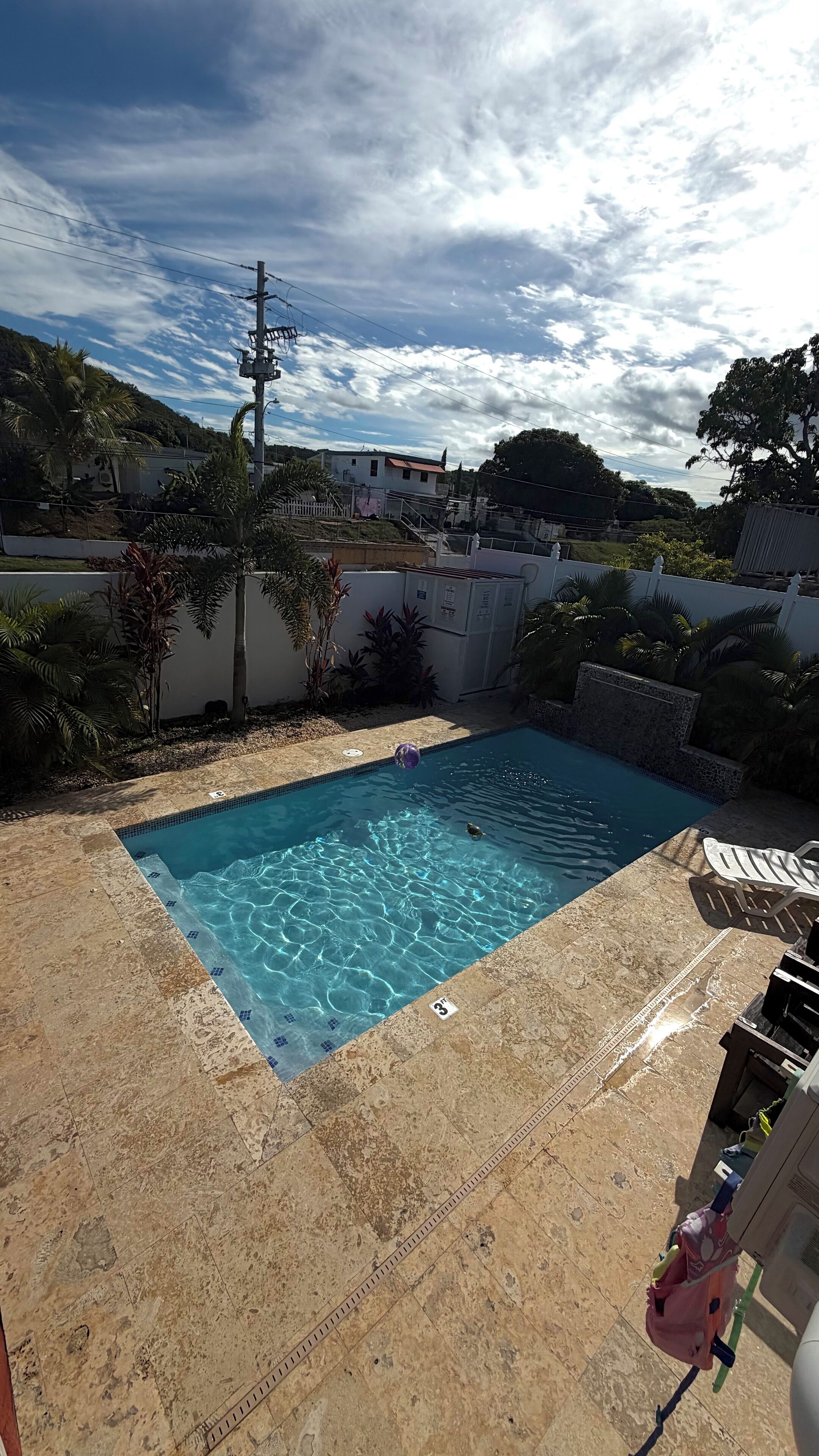 Une piscine à l’eau d’un bleu cristallin, entourée d’une terrasse carrelée.