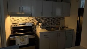A compact kitchen with white cabinets, a built-in oven, a coffee maker, and a sink. - Private House with Pool • Ideal for Families and Couples - Fajardo (Fajardo)
