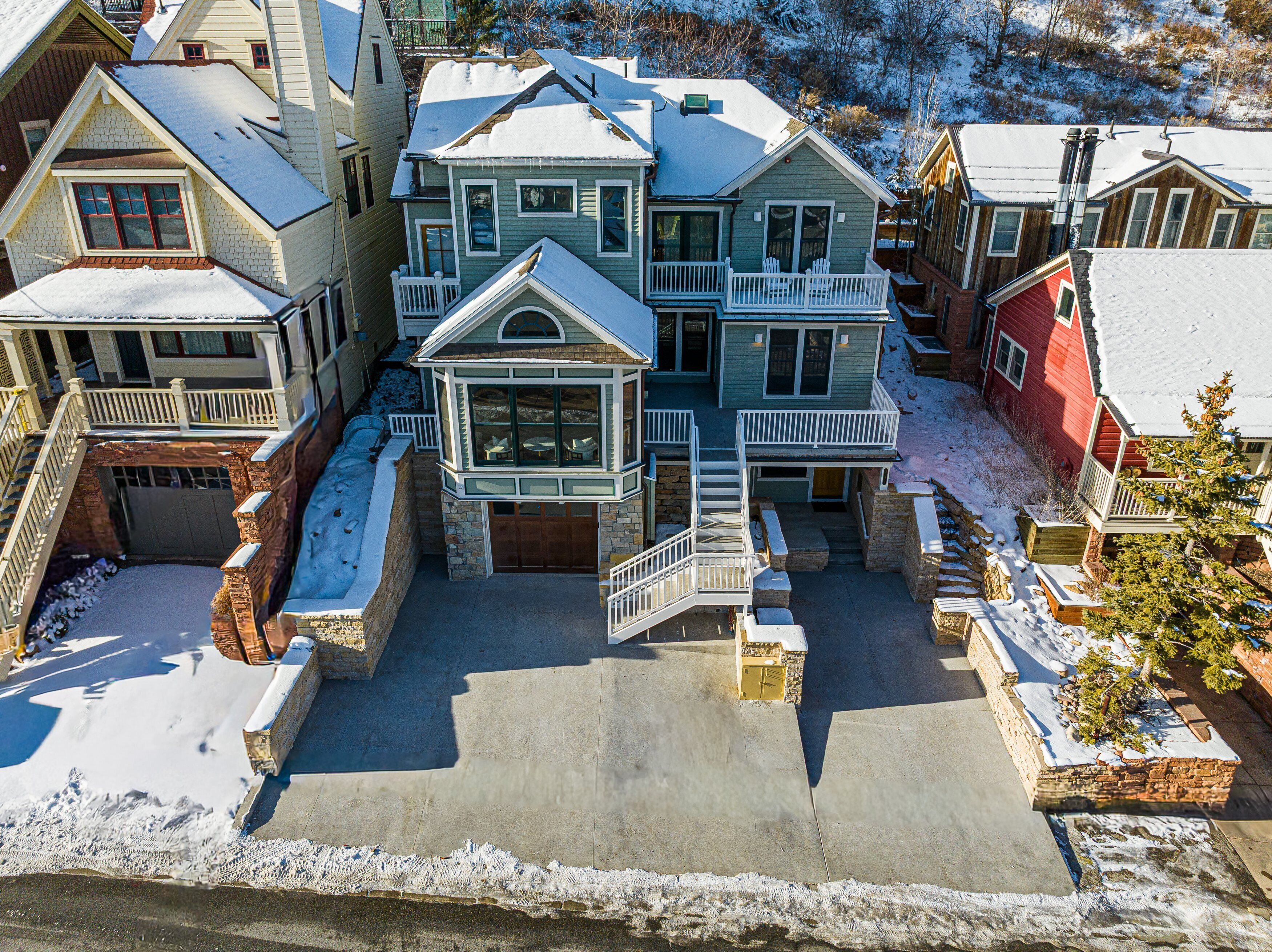 A multi-story residential building with a central courtyard, a covered front porch, and a garage.