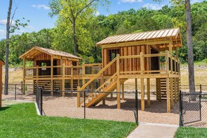 Une structure de jeu en bois comportant plusieurs niveaux et un escalier.