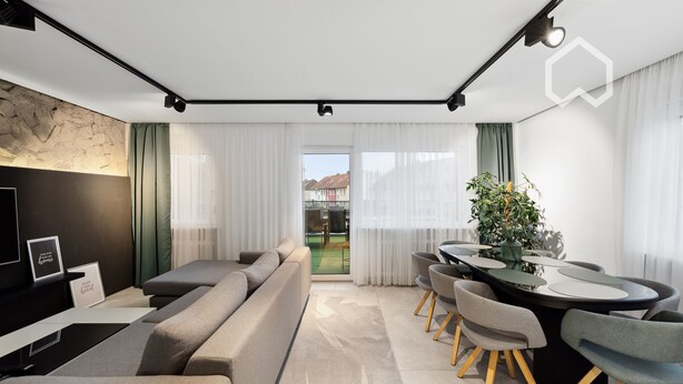 A modern living room with a sofa, dining table, chairs, and a TV.