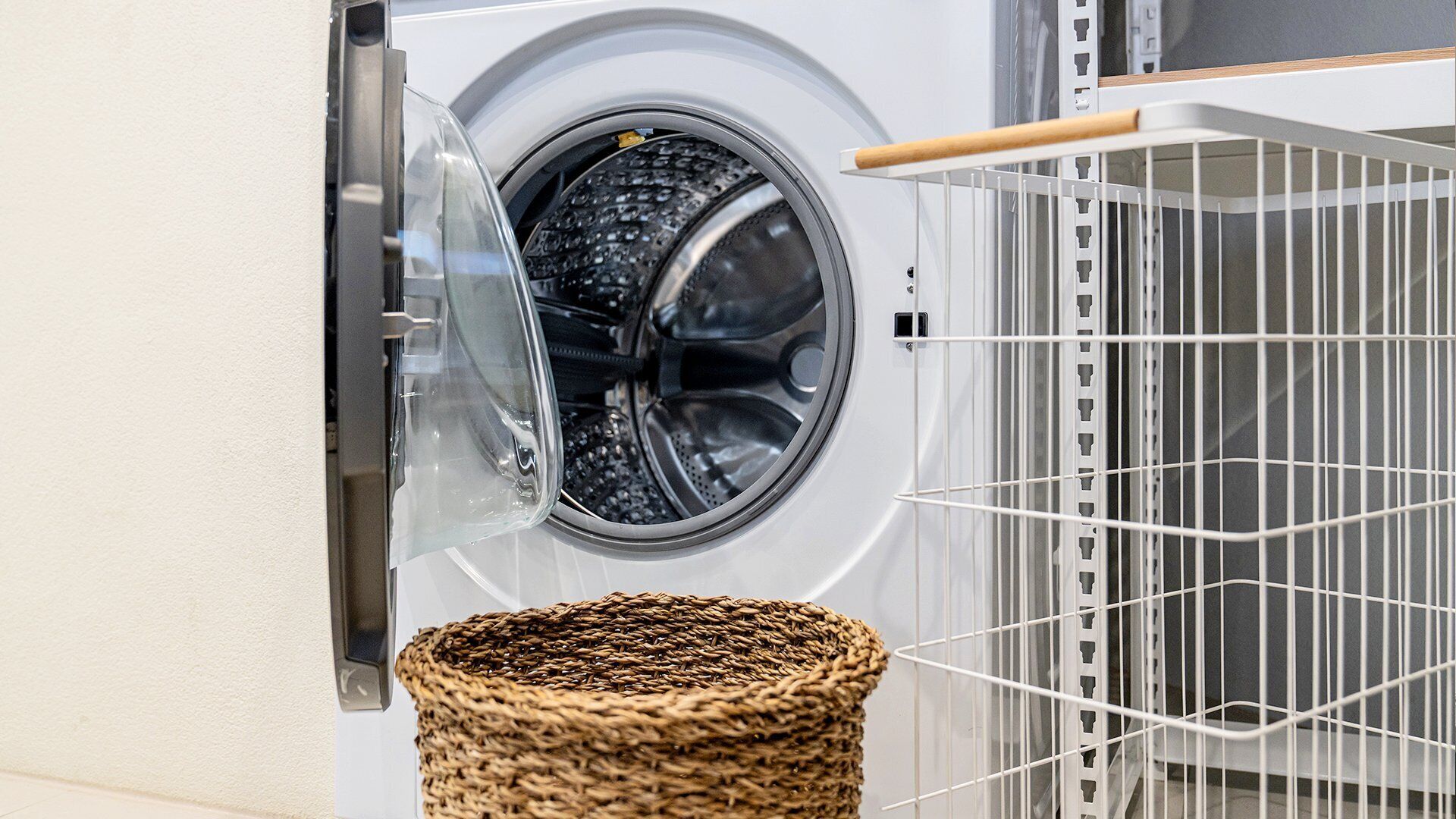 A front-loading washing machine with a basket below it.