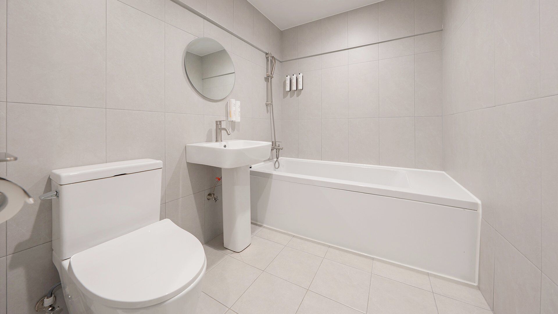 A modern bathroom with a toilet, sink, and bathtub.