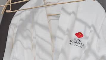 Una prenda blanca con texto bordado y un logotipo de flor roja.
