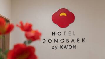 A wall sign for Hotel Dongbaek by Kwon with a red cloud logo.