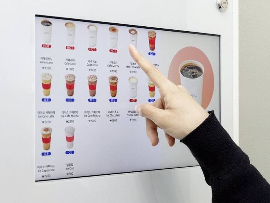 A menu board with various coffee and ice drinks, each labeled with a price.