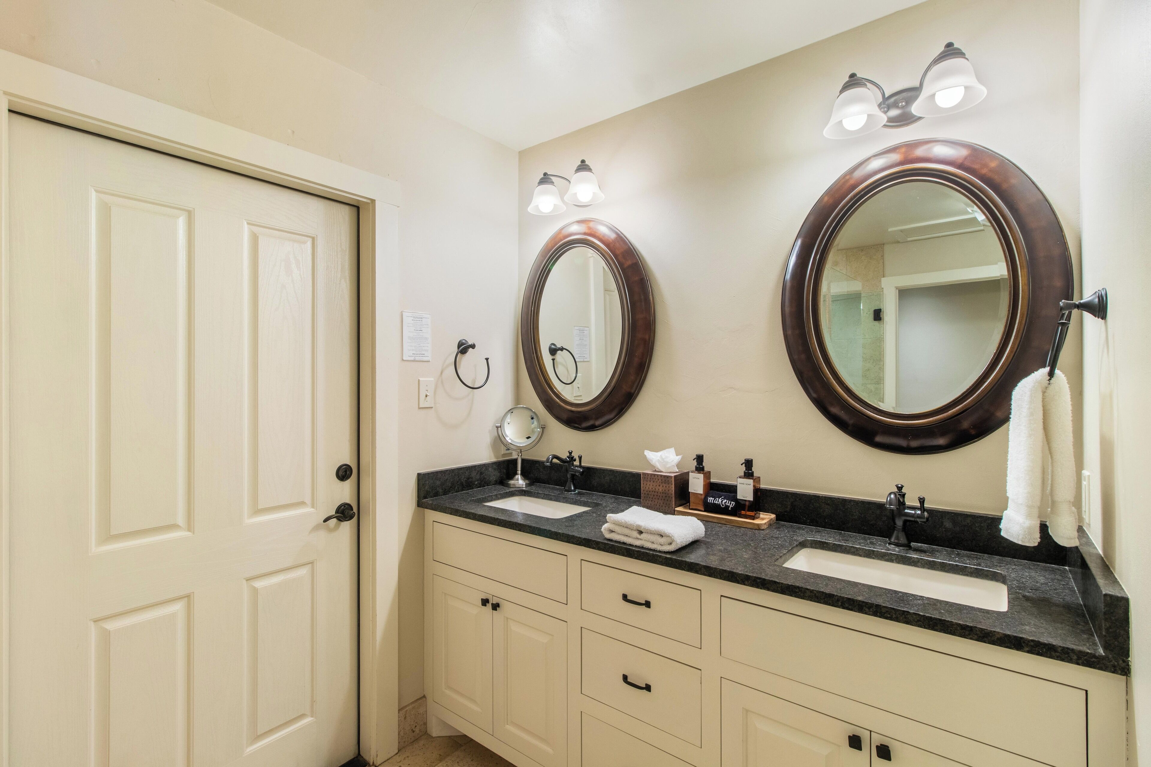 A bathroom with two sinks, a mirror, and a towel rack.