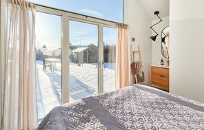 A bedroom with a large sliding glass door leading to a snowy outdoor area. - Amazing home in Middelfart with WiFi (Middelfart)