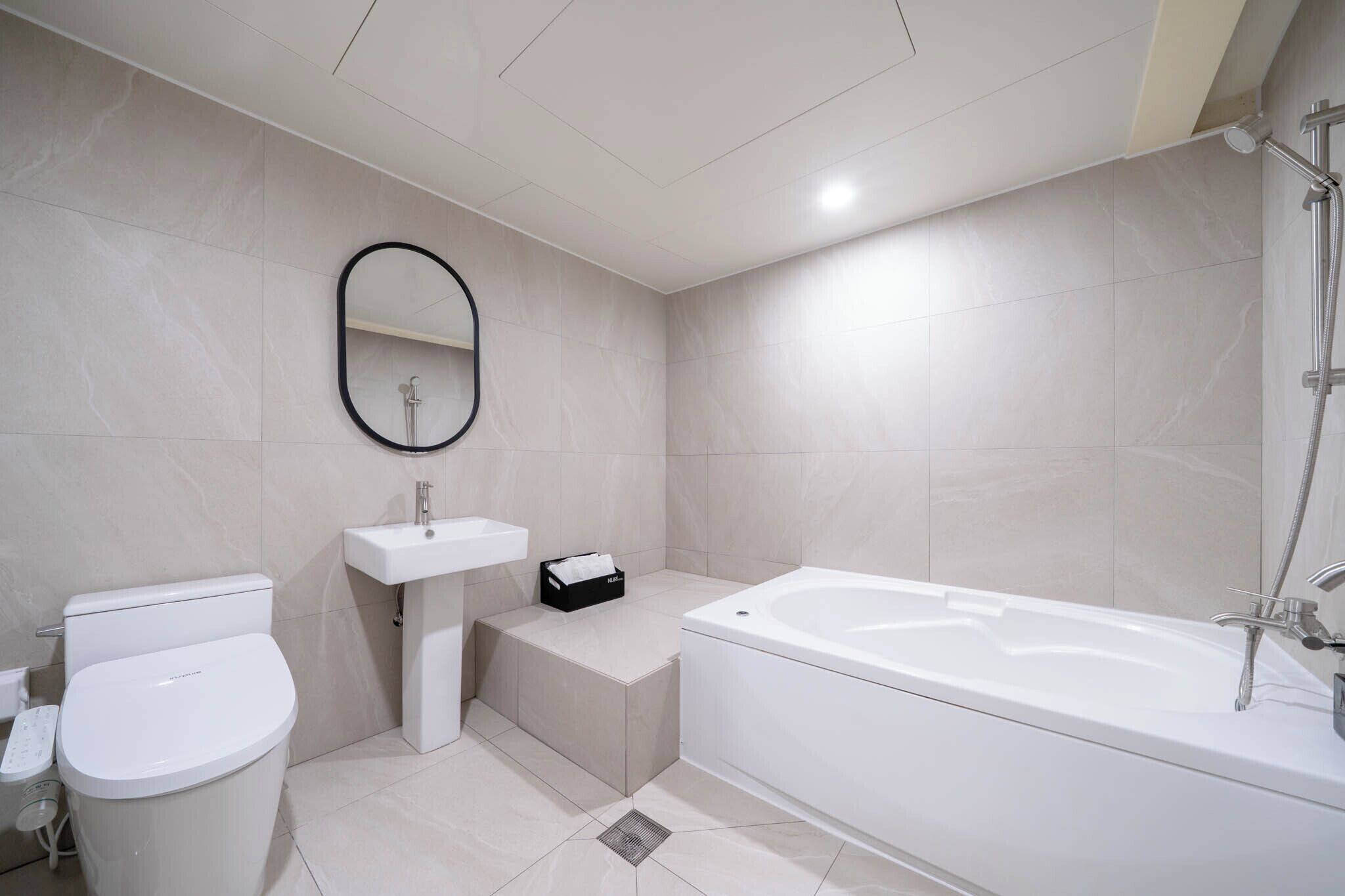 Un baño moderno con inodoro, lavabo y bañera.