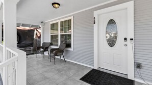 A porch with a white door, a window, and a light fixture. - 3-bedroom house in central San Antonio with AC for comfort (San Antonio)