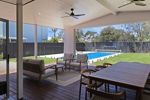 An outdoor patio with a pool, wooden deck, and seating area. - Pool House Barwon Heads 4 bedroom, 2 bathroom, sleeping 8, Heated Pool (Barwon Heads)