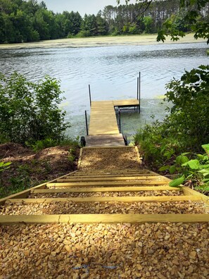 A wooden dock leading to a calm lake surrounded by greenery. - 3bdr cabin in Amery on the Apple River Flowage (Amery)