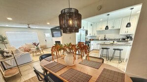 A modern kitchen with white cabinets, a central island, and black bar stools. - Chic & Cozy Retreat w/Pool+Spa /Close to Old Town! (Scottsdale)