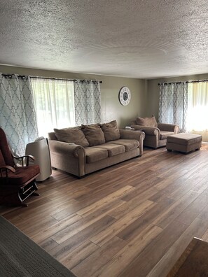 A living room with a sofa set, a chair, and a rug. - Cozy connection near downtown Warren (Warren)