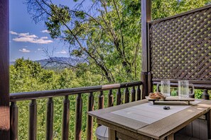 A wooden deck with a table, two glasses, and a plate of food. - Amazing views,  Dollywood, Gatlinburg, pigeon forge under 10miles, 3 kings,games (Sevierville)