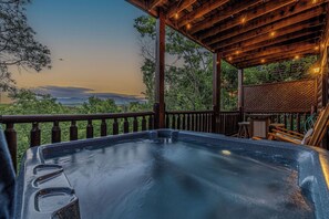 Ein Whirlpool auf einer Holzterrasse mit Blick auf die Landschaft.