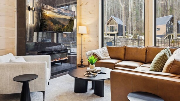 Una sala de estar acogedora con chimenea, un sofá, una mesa de centro y un televisor.