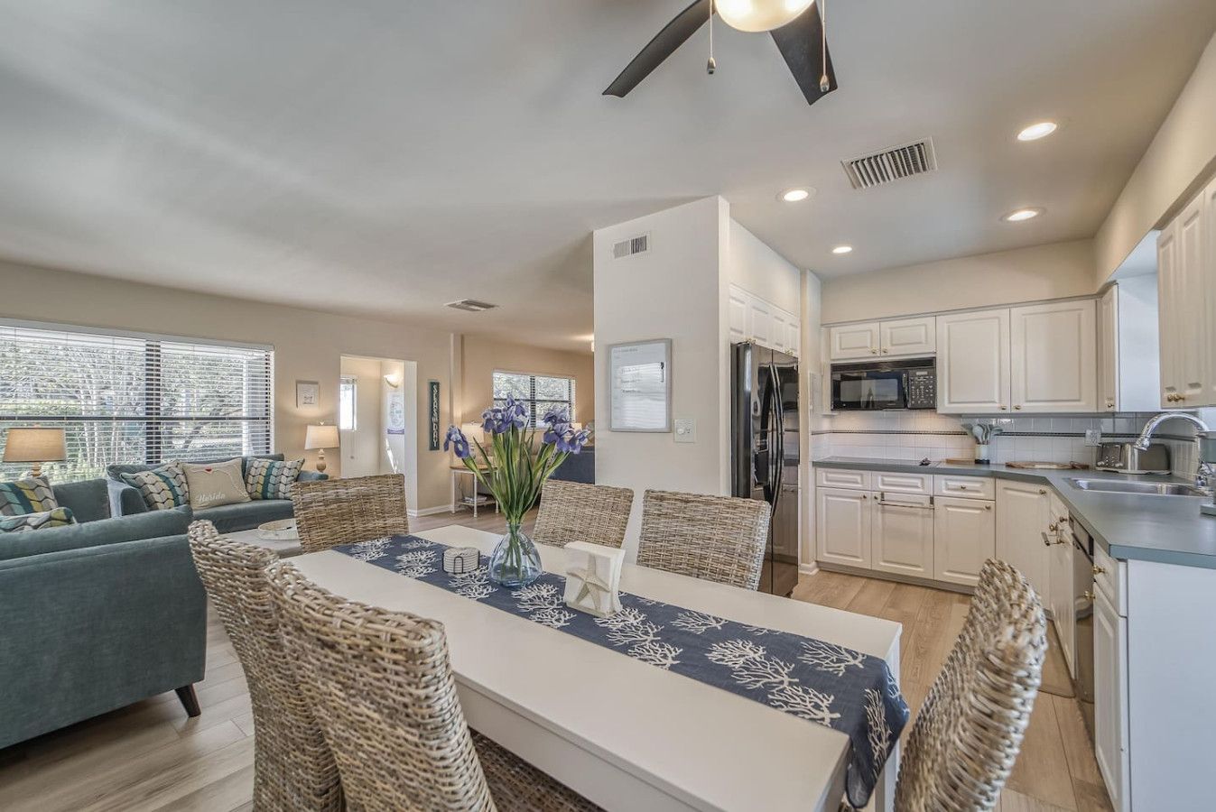 A modern kitchen with white cabinets, a stainless steel refrigerator, and a microwave.