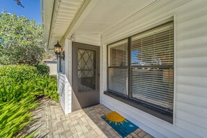 A house with a front door, a window with blinds, a brick pathway, and a doormat. - Coastal Iris - near Gulf beaches, trail, shoppong (Seminole)