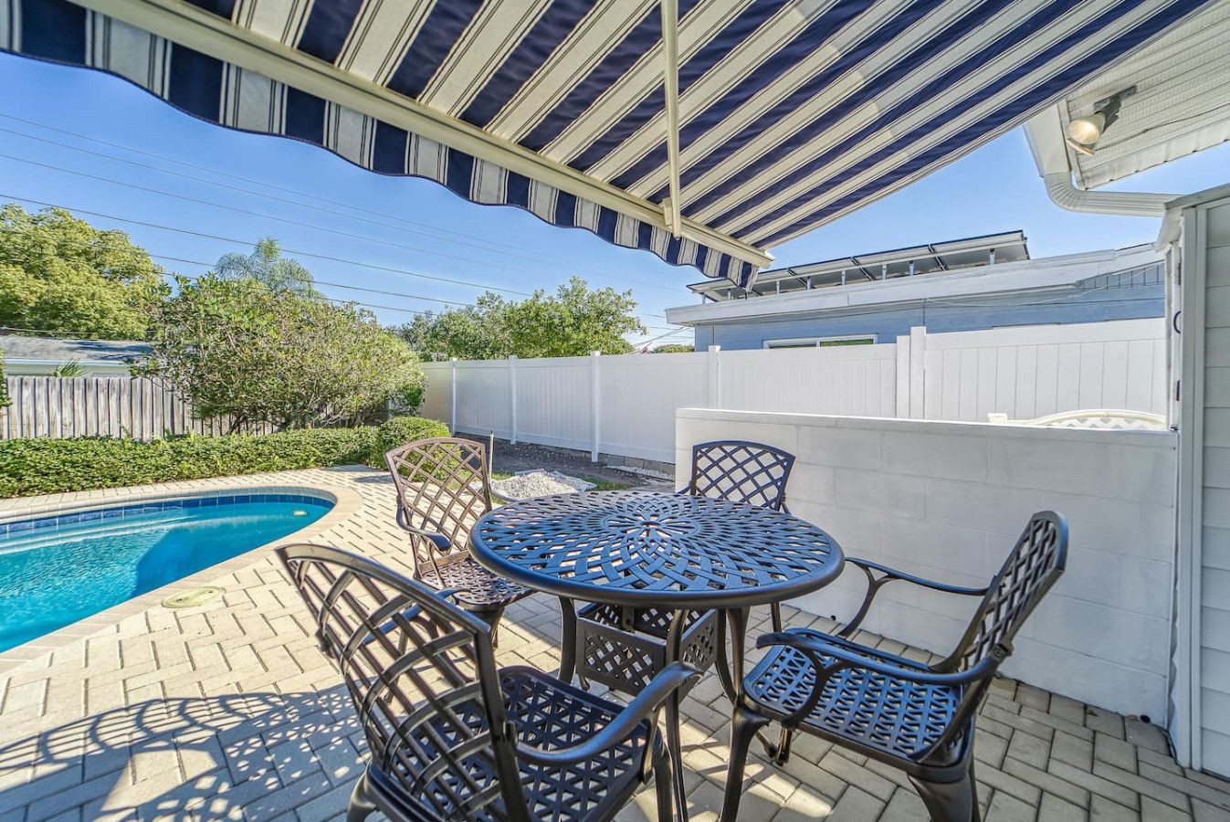 Eine Poolterrasse mit überdachter Sitzgelegenheit und Schwimmbecken.