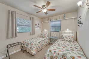 A bedroom with two beds, a ceiling fan, and a small table. - Coastal Iris - near Gulf beaches, trail, shoppong (Seminole)