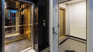 An elevator with a glass door and a control panel, a door with a number sign, and a carpeted floor with a geometric pattern. - 5 min Walk to Taksim Square & Galata sleeps 4 (Beyoglu)