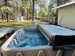 A hot tub in a backyard with a wooden deck, a small shed, and a wooden fence. - Woodhaven House- 1-Acre Bend Oasis, Hot tub, w/office Studio, Pet-Friendly (Bend)