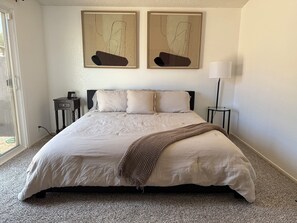 A bedroom with a large bed, two bedside tables, a lamp, and abstract artwork on the wall. - Cienega Springs Getaway (Parker)