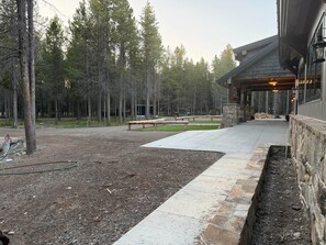 A building with a covered patio area, surrounded by a forested landscape. - Yellowstone Adventure Lodge (Fremont County)