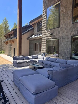 A modern outdoor living area with a sectional sofa and a built-in fire feature. - Yellowstone Adventure Lodge (Fremont County)