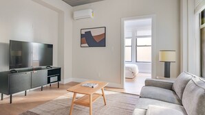 A modern living room with a flat-screen TV, a sofa, a coffee table, and a painting on the wall. - Blueground | Downtown Crossing, view, nr Boston Common (Boston)