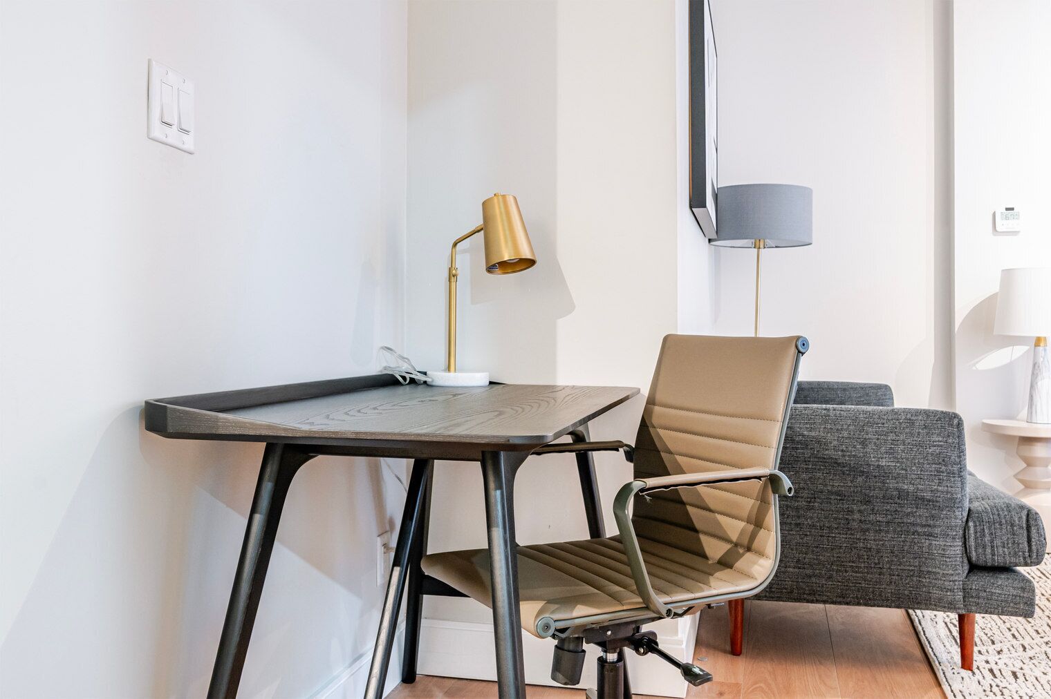 Une chambre moderne équipée d’un bureau, d’une chaise et d’un canapé.