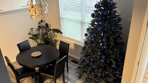 A dining area with a Christmas tree, a chandelier, and a staircase. - Peaceful 3-Bedroom Townhome in Crest Hill /Queen Beds, Full Amenities & Gazebo (Crest Hill)
