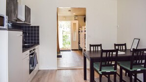 A modern kitchen with a dining area, wooden chairs, and a view into the living space. - Amazing home in Ystad with WiFi (Ystad)