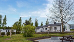 A white mobile home with a patio area, a picnic table, and a small garden. - Amazing home in Ystad with WiFi (Ystad)