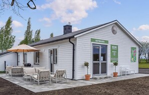 A white building with a reception desk, outdoor seating, and a sign for 'RECEPTION & BUTIK'. - 1 bedroom lovely home in Ystad (Ystad)